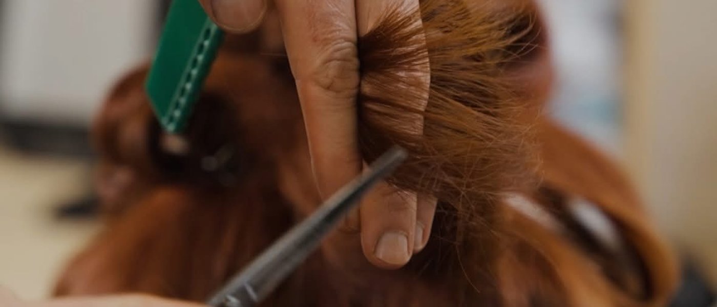 A JAWY stylist sectioning hair with a comb mid-cut